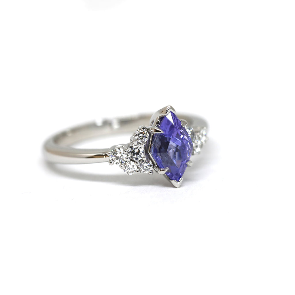Engagement ring in platinum with a stunning fancy shape tanzanite and round brilliant diamonds. A one-of-a-kind engagement ring by Justine Quintal fine jewellery. Feminine exquisite asymmetrical creation. Ruby Mardi is the only fine jewelry gallery in Montreal. We show the creations of the best Canadian jewelry designers. Come see our engagement rings, wedding band and gemstone jewelry. We also offer custom jewelry services in Montreal.