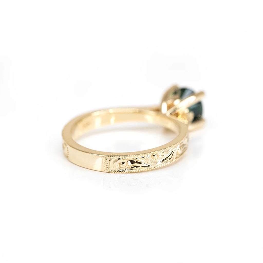 back view of a yellow gold designer engagement ring custom made with a green sapphire from australia at ruby mardi design jeweler montreal on a white background