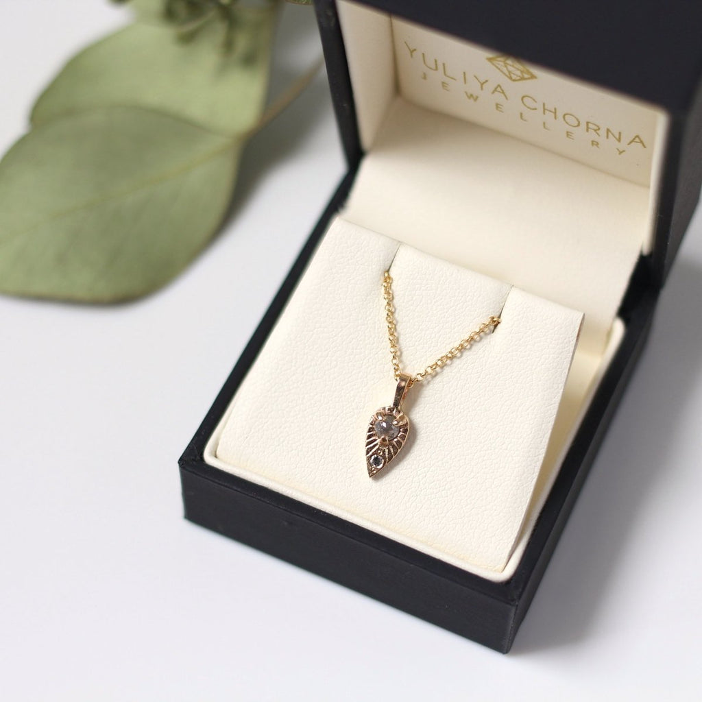 Close up in its box of tear drop sun yellow gold salt and pepper diamond handmade in Toronto by Yuliya Chorna and available in Montreal at Jewelry Store Ruby Mardi.