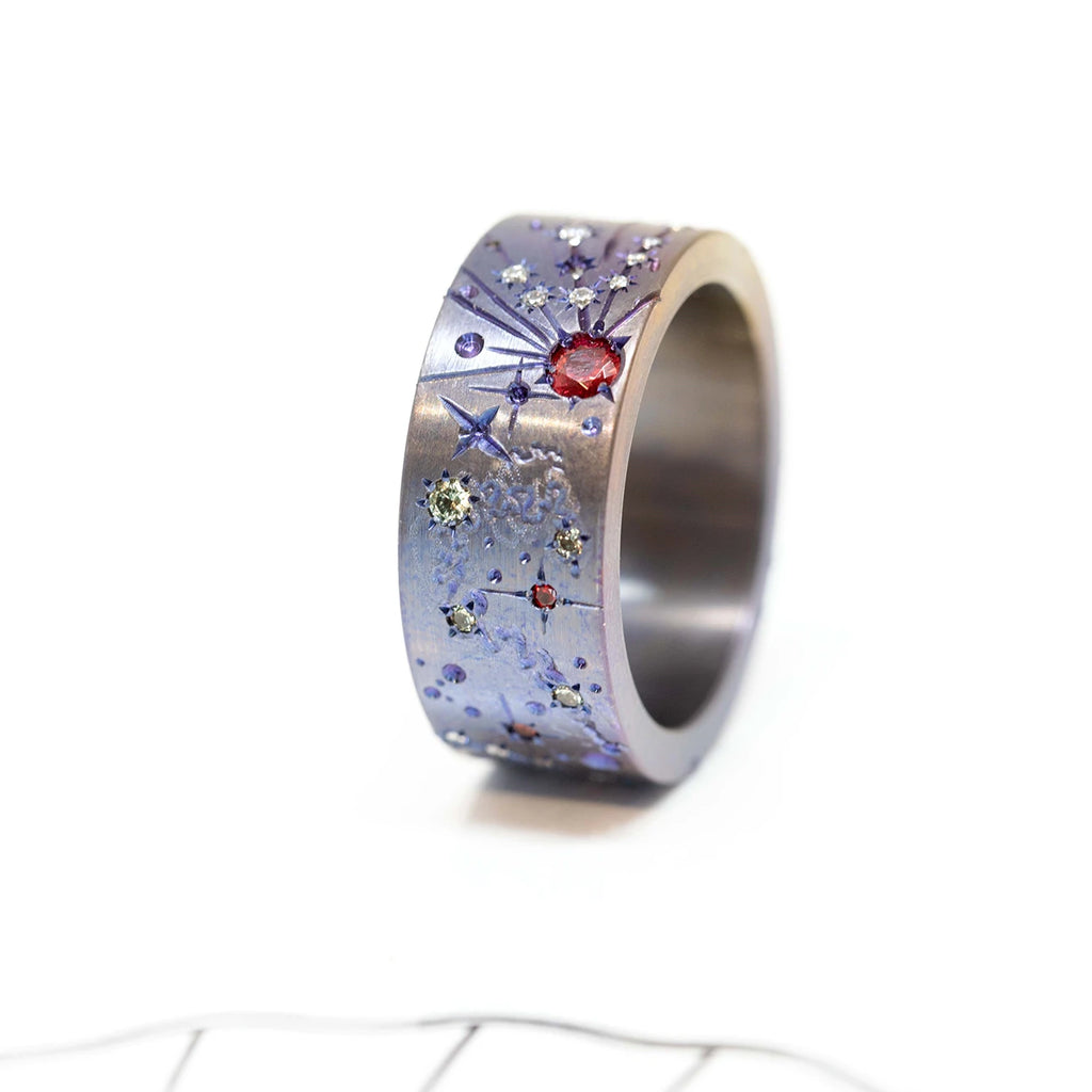 front view of Titanium men ring with colored gemstones red and yellow sapphire handmade bu the best jewelry designer in canada Janine de Dorigny fine texurted jewels on a white background