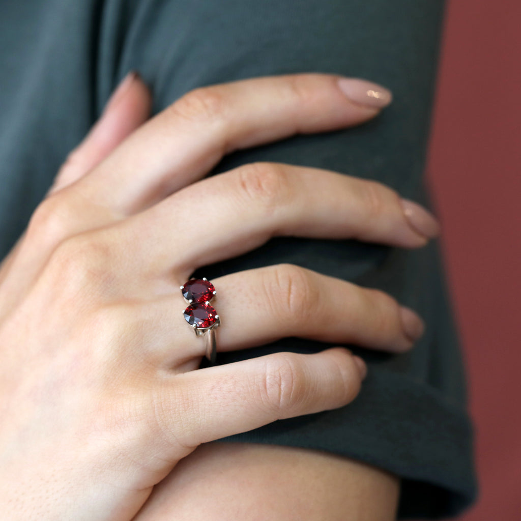Statement ring in sterling silver featuring two oval pyrope garnet, worn by a lady. Find this modern one-of-a-kind ring and other unique pieces of jewelry at our jewelry store in Montreal, or at our online store.
