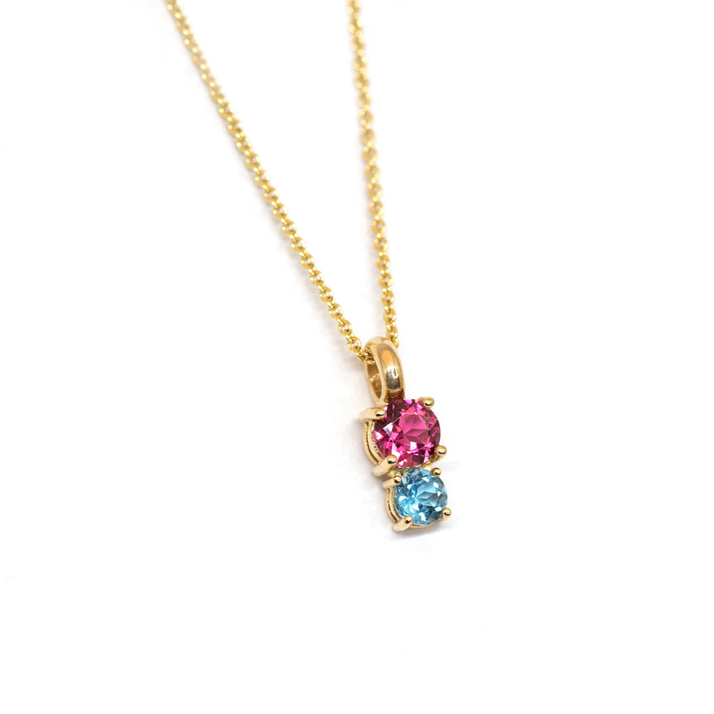 Lico Jewelry presents this minimalist yellow gold pendant with two round colored gems, including a pink tourmaline and a sky blue topaz gem. This you and me pendant is a one-of-a-kind creation made in Montreal and available for sale at the Ruby Mardi jewelry store.