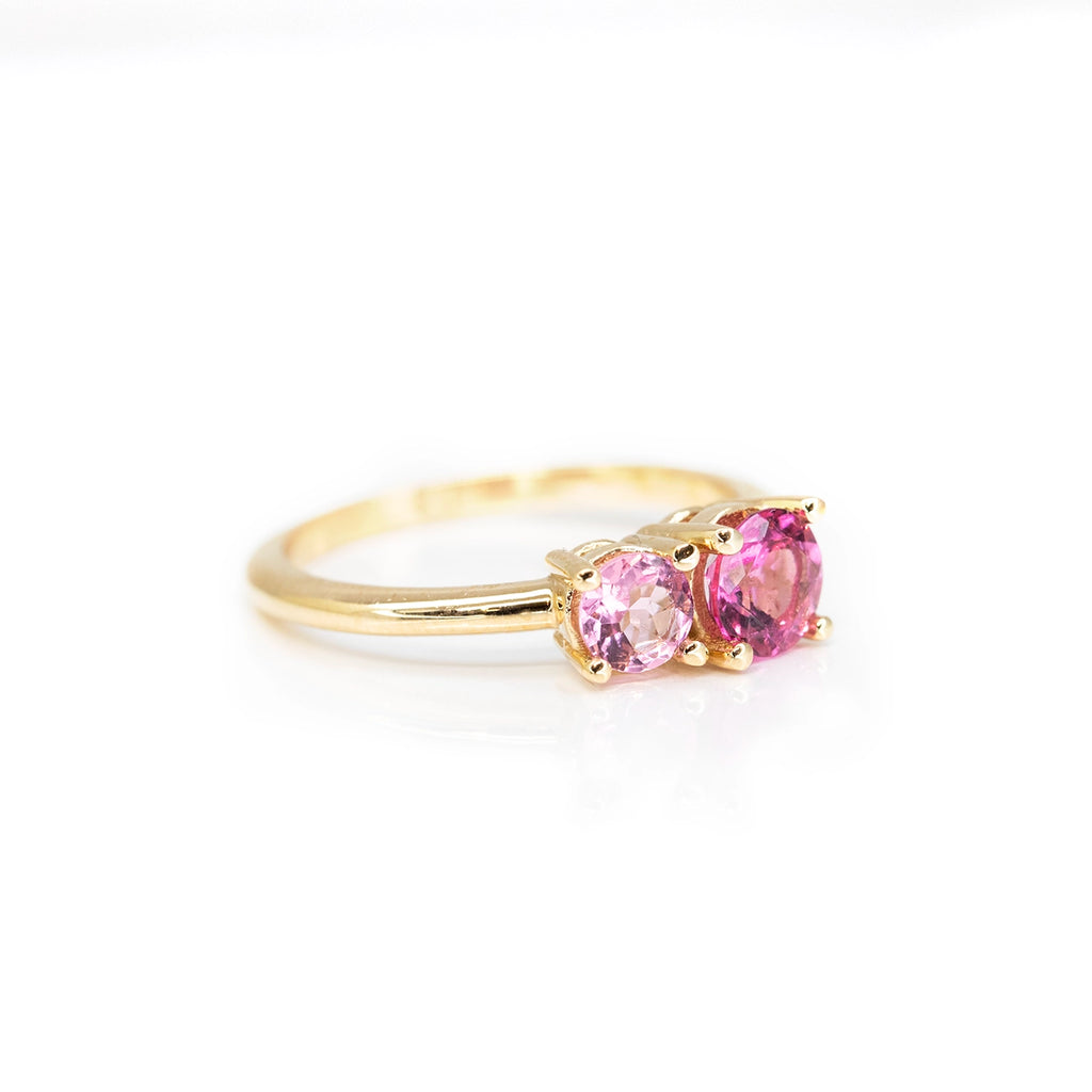 side view of round shape pink tourmaline toi et moi minimalist colored gemstone engagement ring made in ruby mardi best jewelry store in montreal on a pink background