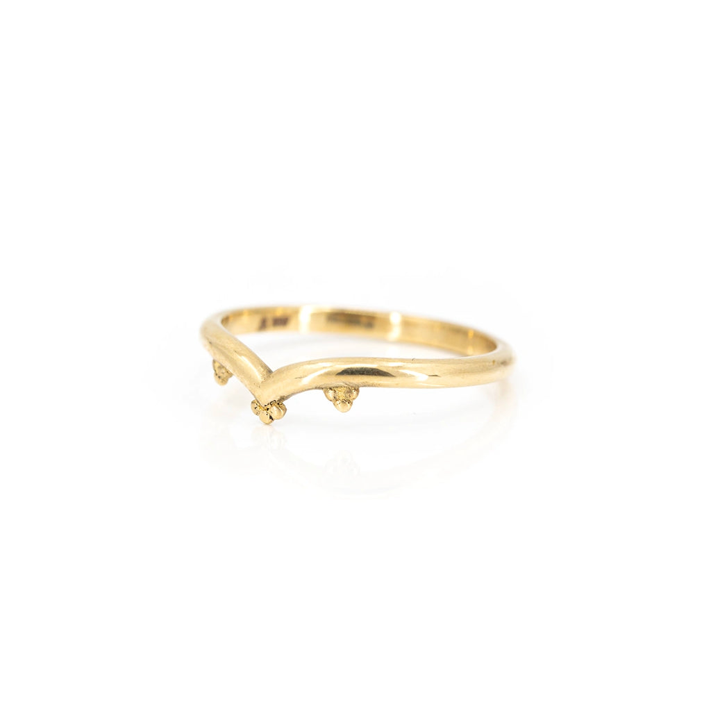 V shape organic yellow gold wedding band photographed on a white background and seen from half side. Alternative bridal jewelry that can be found at fine jewellery store Ruby Mardi in Montreal’s Little Italy.