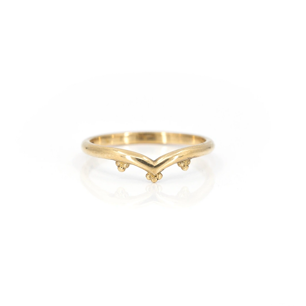 Yellow gold band in V shape with chevron photographed on a white background. Alternative organics wedding bridal jewelry that can be found at fine jewellery store Ruby Mardi in Montreal’s Little Italy.