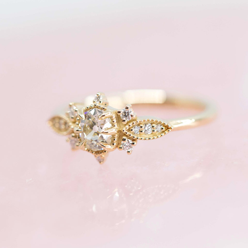 Amazing engagement ring with 13 diamonds set in 10k yellow gold and handmade in Toronto by jeweler Nadia Werchola. Seen here on a quartz rose background.