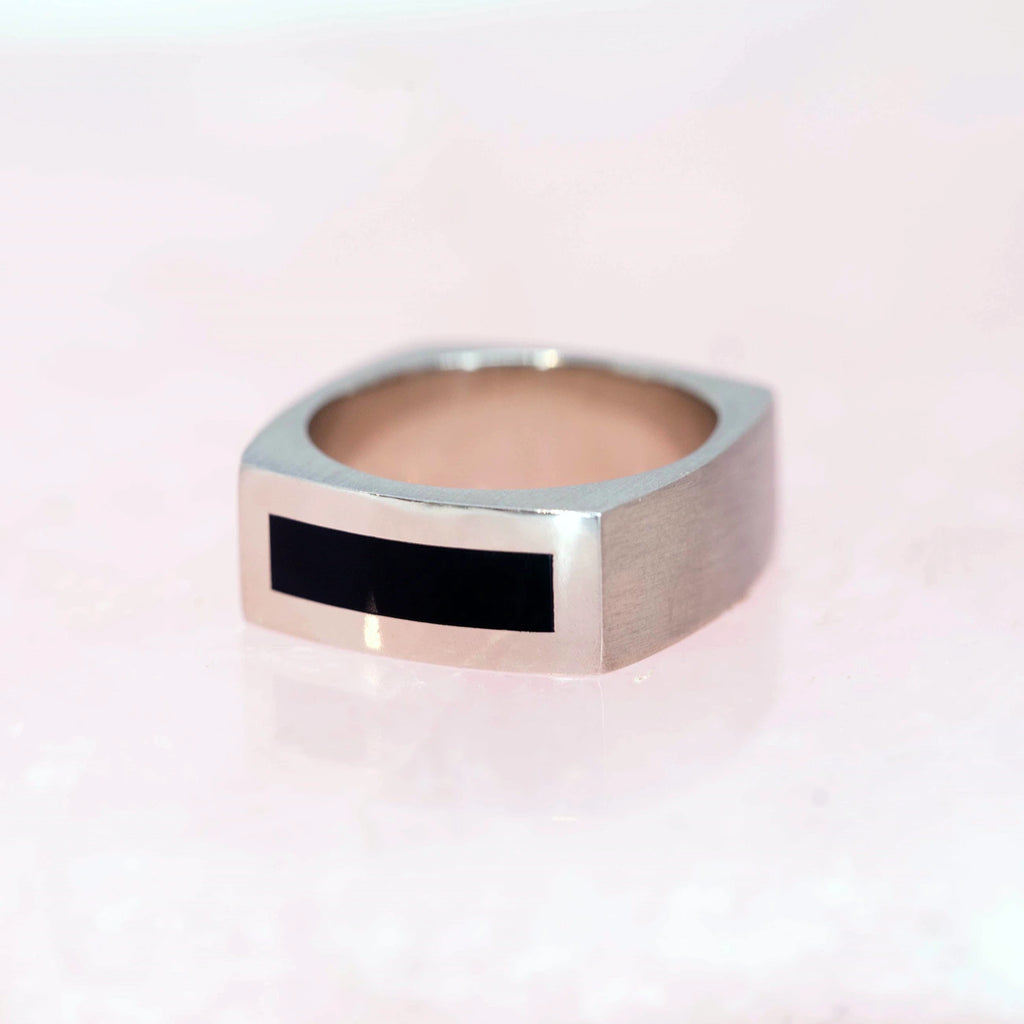 onyx and white gold men ring custom made in montreal cool edgy wedding band by the best jewellery designers in canada boutique ruby mardi on a pink background
