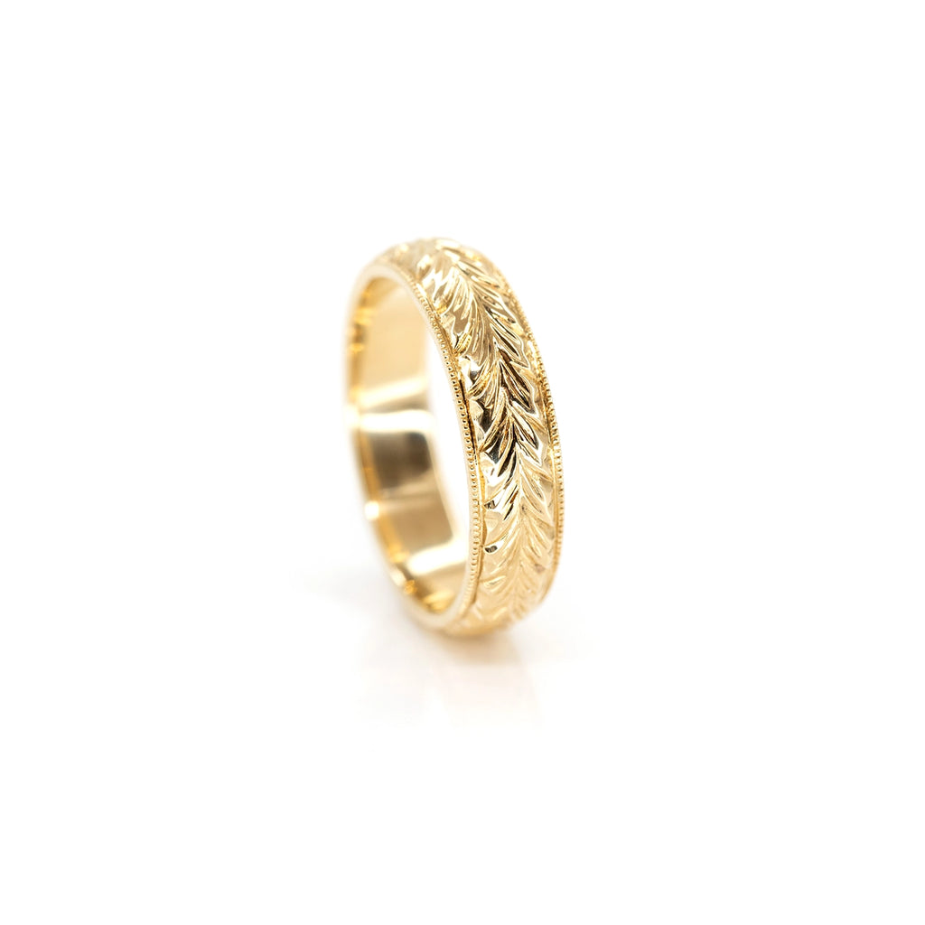 front view of engraved yellow gold engagement ring marching wedding band custom made by deborah lavery designer for the best jewelry store boutique ruby mardi montreal on a white background
