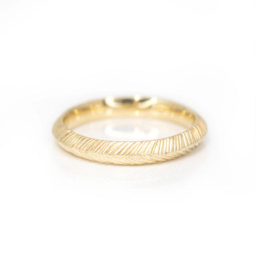 yellow gold textured artisan jewelry designer sheena from montreal yellow gold wedding band made in canada on a white background