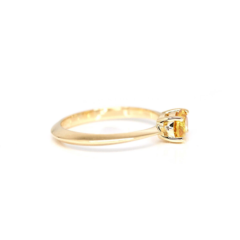 side view of minimalist bridal yellow gold ring made with colored sapphire simple custom made jewels at boutique ruby mardi finest jeweler in canada on a white background