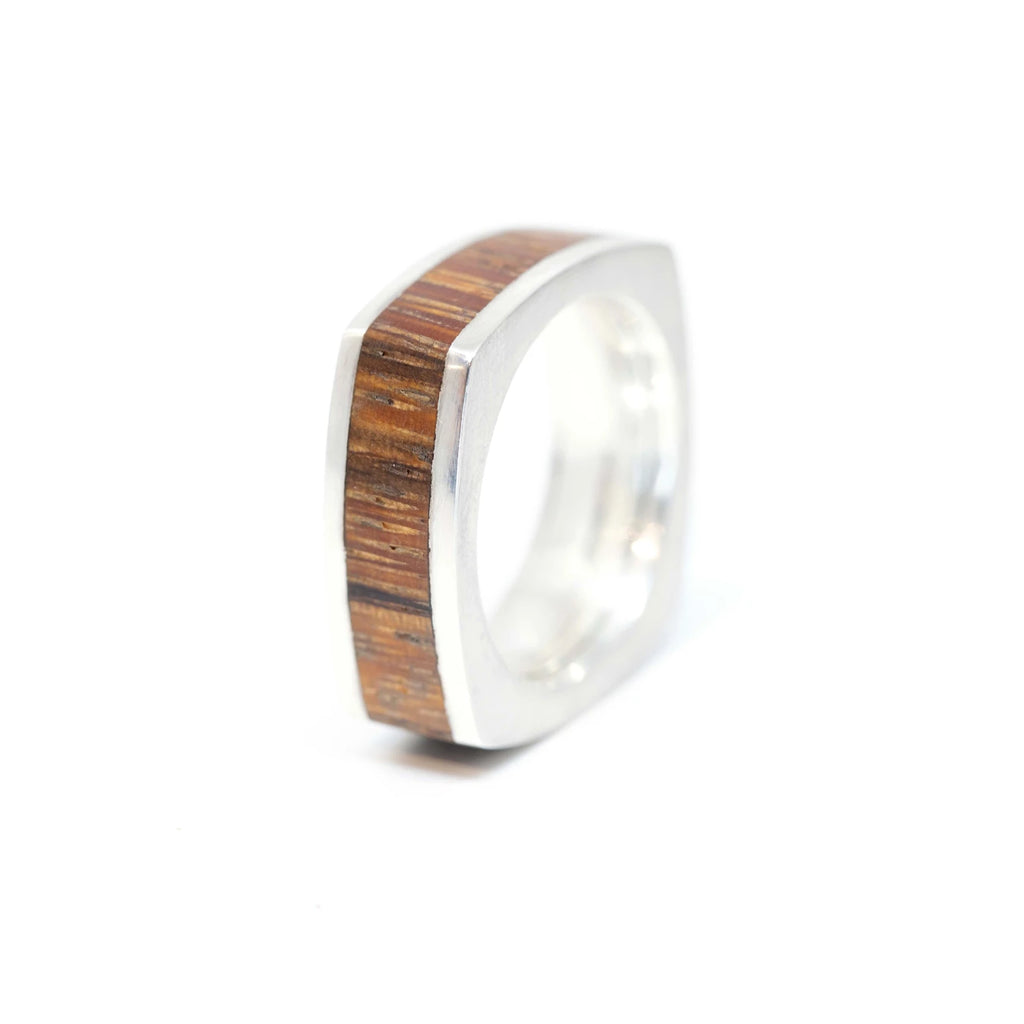 top view of wood and silver men fine jewelry and wedding band custom engagement ring available at the best jeweler in montreal ruby mardi designer Janine de Dorigny on a white background