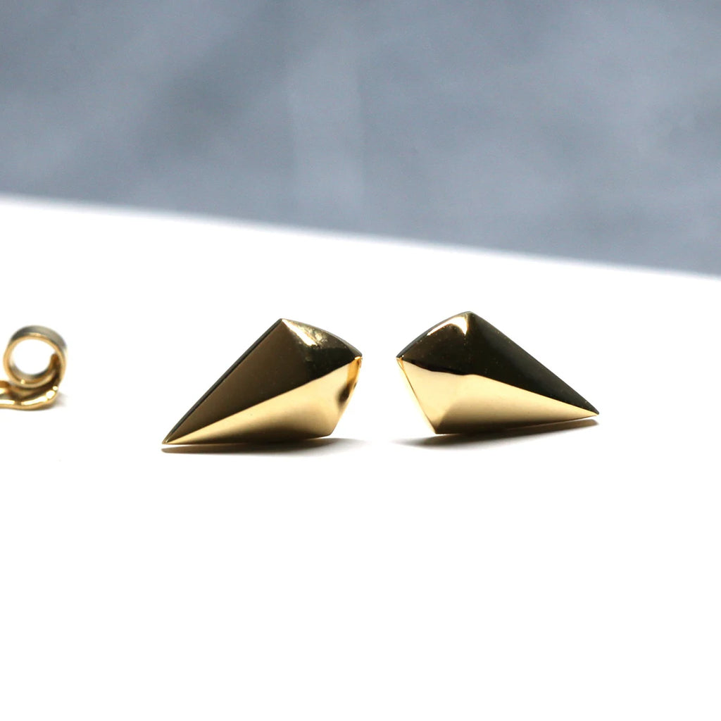 Front view of geometric stud earrings for sale at Ruby Mardi jewelry, with butterfly backs in yellow and white gold, displayed on a white background.