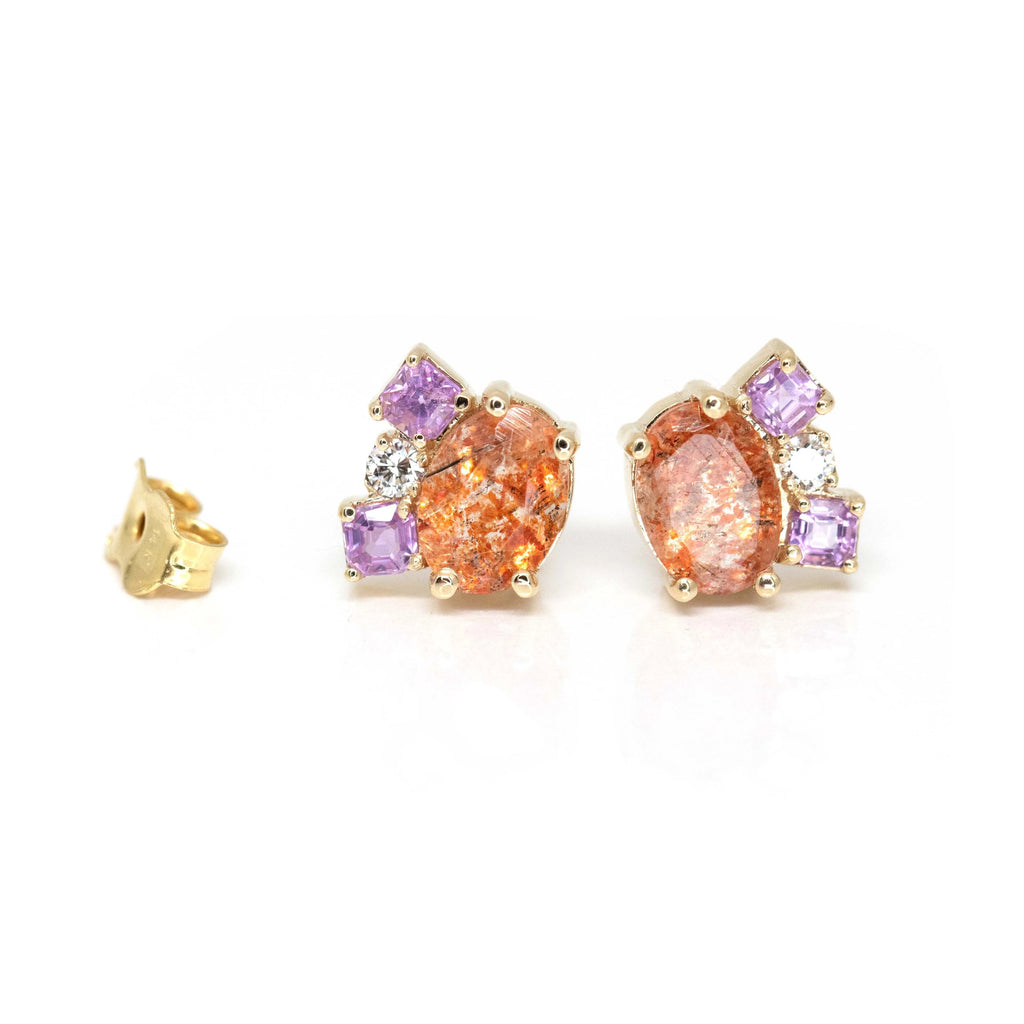 front view of oval shape orange gemstone purple sapphire and diamond earrings custom made in montreal at the best jewellery store ruby mardi by the fine bena jewelry on a white background