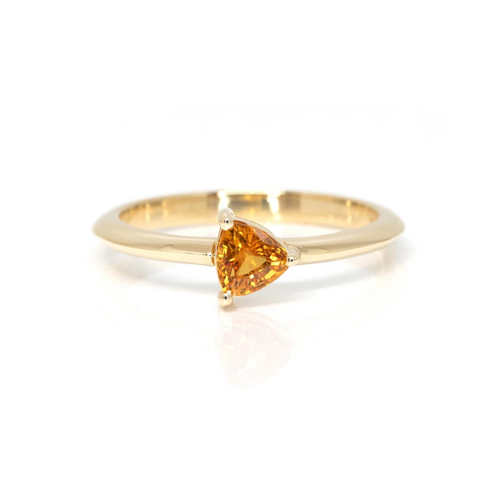 Orange sapphire trillion shape yellow gold bridal ring handmade in Montreal by local jewellery brand Bena Jewelry seen here on a white background.